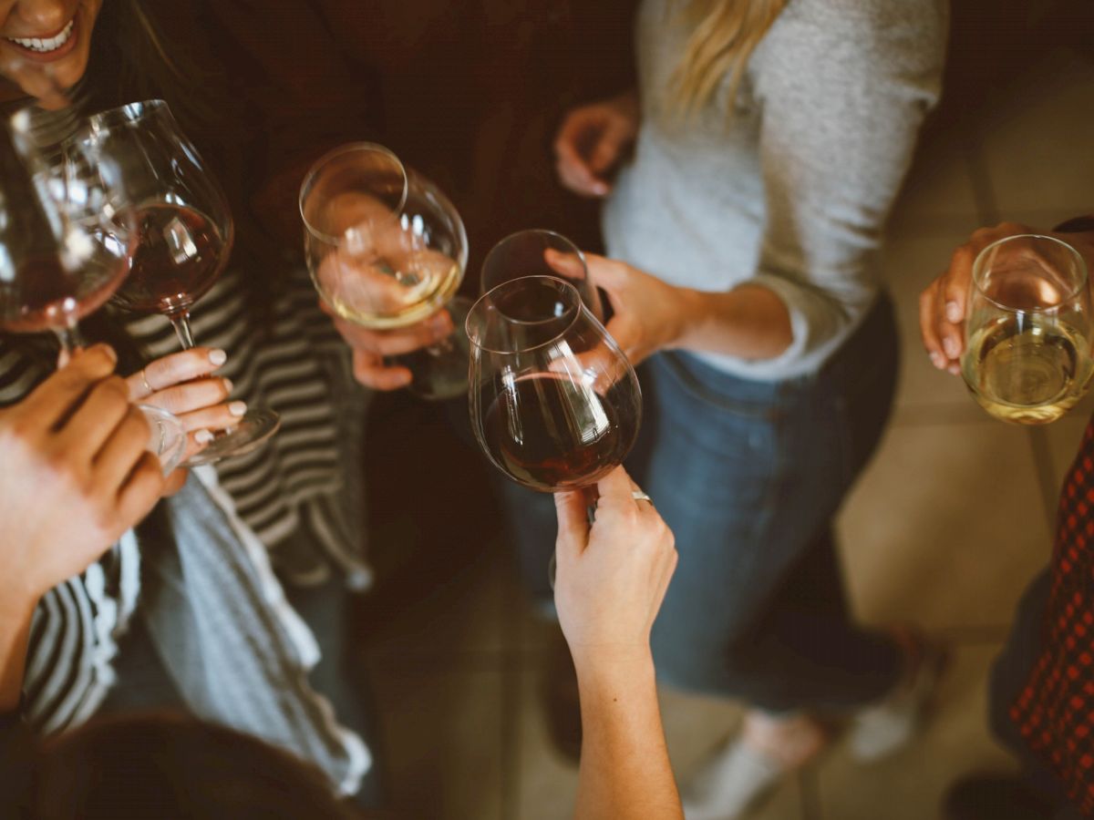 A group of people are holding glasses of wine, seemingly enjoying a social gathering or celebration.